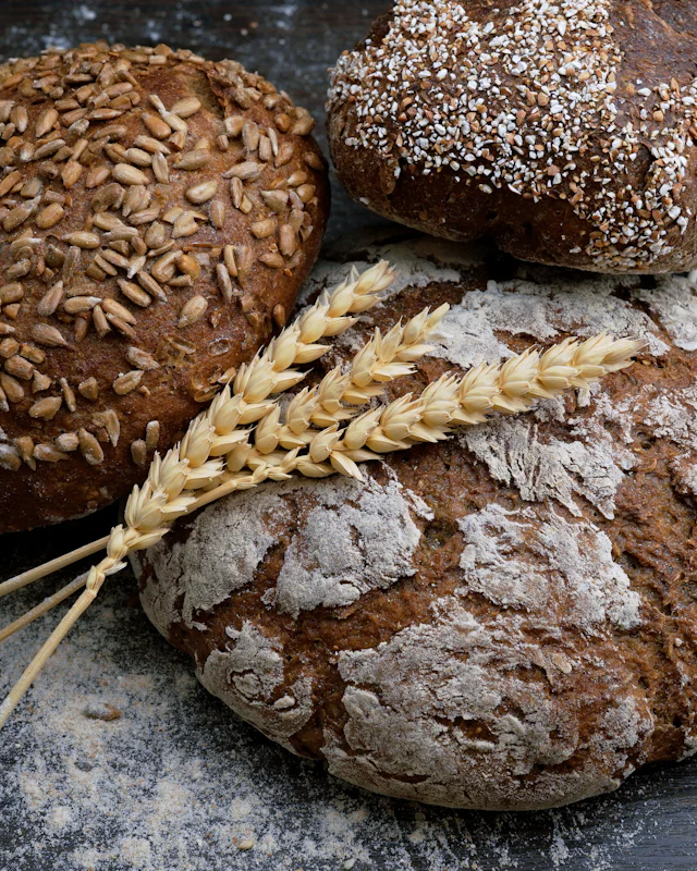 Loaves of seeded rye bread with wheat stalks